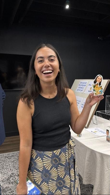 Smiling guest holding up her personalized bobblehead at an evening event