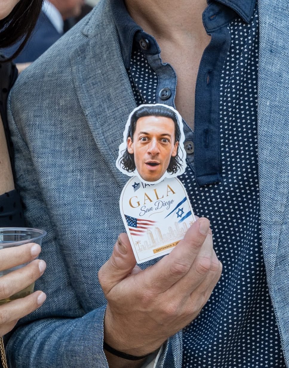 Gala guest in a blazer holding his TinyTwin with a custom gala base
