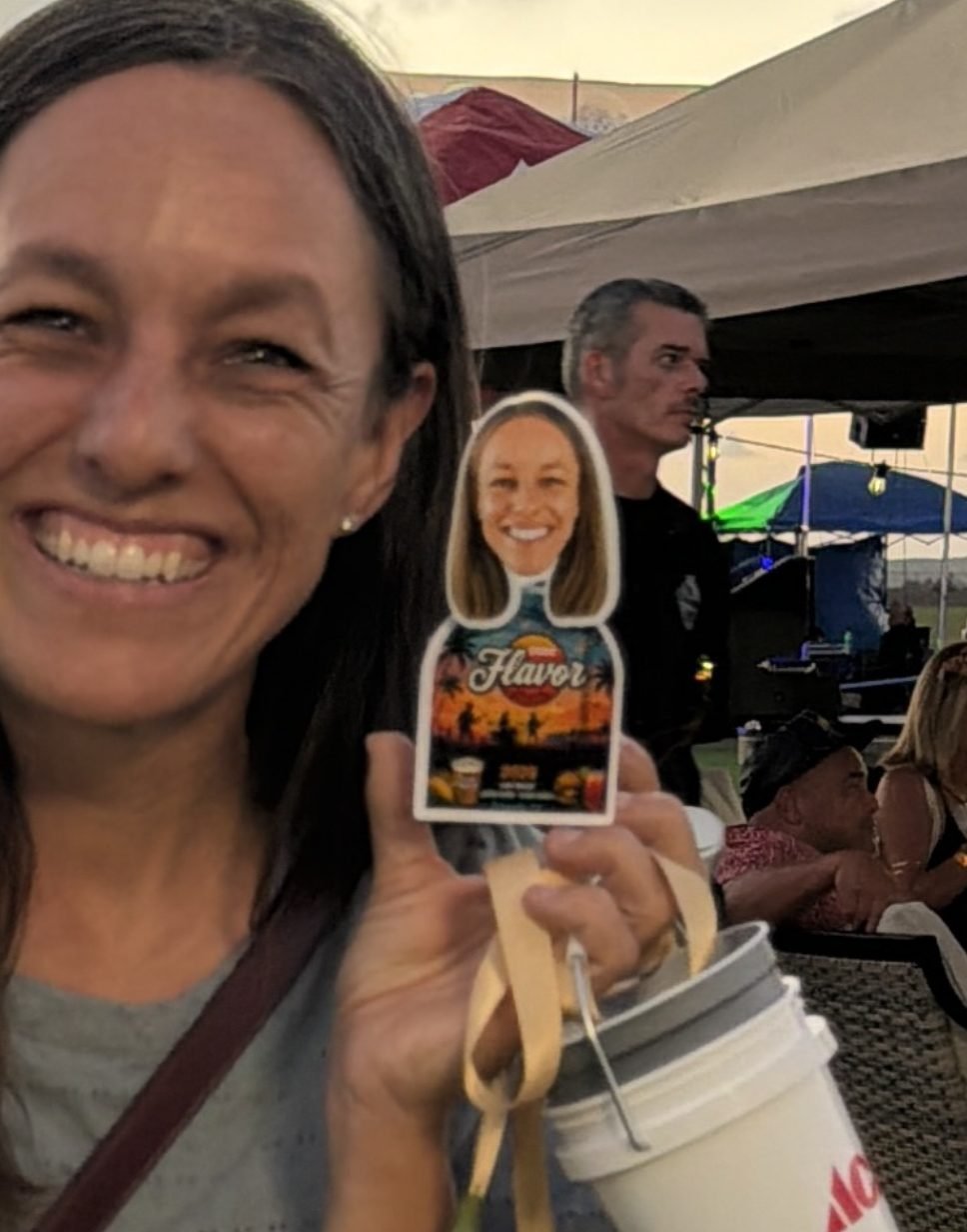 Smiling guest holding her personalized TinyTwin at an outdoor festival